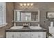 Bathroom featuring a double vanity with framed mirror and decorative lighting fixtures at 131 Long Shadow Ln, Cary, NC 27518