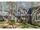 Townhome featuring dormer windows and a beautiful brick walkway amidst mature trees at 131 Long Shadow Ln, Cary, NC 27518