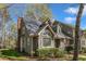 Townhome featuring gray siding, well-manicured landscaping, and a brick chimney at 131 Long Shadow Ln, Cary, NC 27518