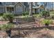 Comfortable outdoor bench, landscaping, and well maintained townhome with brick walkway in the background at 131 Long Shadow Ln, Cary, NC 27518