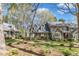 View of gray home with dormer windows, brick walkway, and lush green lawn and landscaping at 131 Long Shadow Ln, Cary, NC 27518