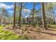 A row of townhomes in a wooded neighborhood with mature landscaping and brick walkways at 131 Long Shadow Ln, Cary, NC 27518