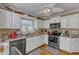 Well-lit kitchen with white cabinets, granite countertops, and stainless steel appliances at 131 Long Shadow Ln, Cary, NC 27518