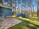 Backyard featuring a patio, a grassy area, and a row of storage sheds with matching blue siding at 1402 Valley Rd, Garner, NC 27529