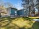 Backyard view featuring a well-maintained lawn, a small back patio, and a home with blue siding at 1402 Valley Rd, Garner, NC 27529