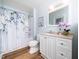 Freshly renovated bathroom with decorative shower curtain, modern vanity, and light blue walls at 1402 Valley Rd, Garner, NC 27529