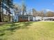 Inviting blue house with a well-manicured lawn, a single car garage, and a large carport at 1402 Valley Rd, Garner, NC 27529