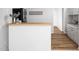 The kitchen features a wood breakfast bar, white cabinets and a decorative 