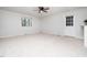 Bright living room with a ceiling fan, a side access door and neutral carpeting at 1402 Valley Rd, Garner, NC 27529