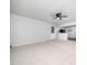 Spacious living room with neutral carpet, white walls, a ceiling fan, and kitchen access at 1402 Valley Rd, Garner, NC 27529