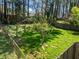Expansive backyard with lush green grass, mature trees, and a well-maintained fence at 1507 Ridgeway Ave, Durham, NC 27701