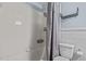 Clean bathroom featuring a shower with a curtain, white tiling, and toilet at 1507 Ridgeway Ave, Durham, NC 27701