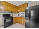 This kitchen features light wood cabinetry, black appliances, and double basin sink at 1507 Ridgeway Ave, Durham, NC 27701