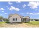 Rear exterior view of a home with a screened porch, grassy backyard and blue skies at 151 S Harper Faith Way, Benson, NC 27504
