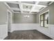 Elegant dining room boasting coffered ceilings, wainscoting, a modern chandelier, and beautiful dark floors at 151 S Harper Faith Way, Benson, NC 27504