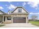Detailed view of a stone accented two-car garage with paneled garage door on a two-story home at 151 S Harper Faith Way, Benson, NC 27504