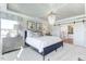 Elegant bedroom with tray ceiling, decorative lighting, and sliding door leading to en suite bathroom at 1515 Willbrook Dr, Fuquay Varina, NC 27526