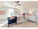 Bright bedroom with a ceiling fan, sitting area, and beautiful floral-patterned bedding at 1515 Willbrook Dr, Fuquay Varina, NC 27526