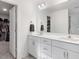 Bright bathroom with double sink vanity, white cabinets, large mirror, and walk-in closet at 182 Mill Bend Dr, Fuquay Varina, NC 27526
