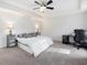 Spacious bedroom with tray ceilings features neutral carpeting, a ceiling fan, and ample natural light at 182 Mill Bend Dr, Fuquay Varina, NC 27526