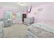 Bedroom featuring pink walls, hardwood floors, crib, accent chair, and ample natural light at 182 Mill Bend Dr, Fuquay Varina, NC 27526