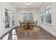 Bright dining area features wood floors, a round table with six chairs, and large windows with wooded views at 182 Mill Bend Dr, Fuquay Varina, NC 27526