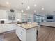 Open concept living with kitchen island, stainless steel appliances, living area featuring sofa and TV at 182 Mill Bend Dr, Fuquay Varina, NC 27526