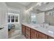Bathroom featuring double vanity, white countertops, and framed mirror with decorative lighting fixtures at 182 Prince Place Dr, Fuquay Varina, NC 27526