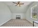 Bright bedroom with neutral carpet, a ceiling fan, and a window offering scenic views of the surrounding landscape at 182 Prince Place Dr, Fuquay Varina, NC 27526