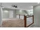 Bright bonus room with neutral carpet, ceiling fan, and a view of the stairs leading down at 182 Prince Place Dr, Fuquay Varina, NC 27526