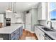 Bright kitchen features a gray island, granite countertops, stainless appliances, and hardwood floors at 182 Prince Place Dr, Fuquay Varina, NC 27526