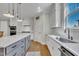 Well-lit kitchen featuring a gray island, white cabinets, and stainless steel appliances at 182 Prince Place Dr, Fuquay Varina, NC 27526
