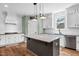 Bright kitchen features shaker cabinets, gray island, granite countertops, stainless appliances, and hardwood floors at 182 Prince Place Dr, Fuquay Varina, NC 27526