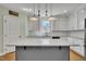 Bright kitchen with white cabinets, gray island, and modern pendant lighting at 182 Prince Place Dr, Fuquay Varina, NC 27526