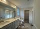 Double vanity bathroom featuring a framed mirror and modern light fixtures at 187 Regis Ln # 10, Coats, NC 27521