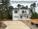 Charming two-story home featuring a light exterior, attached garage, and inviting front porch with stately columns at 187 Regis Ln # 10, Coats, NC 27521