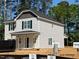 New two-story home featuring light siding, black shutters, and a covered front porch nestled on a wooded lot at 187 Regis Ln # 10, Coats, NC 27521