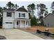 Two-story home with gray siding, black shutters, attached garage, and a long driveway in a wooded neighborhood at 187 Regis Ln # 10, Coats, NC 27521