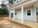 Exterior view of a home featuring white columns supporting a porch, complemented by light gray siding and natural light at 187 Regis Ln # 10, Coats, NC 27521