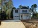 Charming two-story home featuring a one-car garage, a welcoming porch and a neatly paved driveway at 187 Regis Ln # 10, Coats, NC 27521