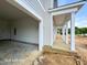 Open garage showcasing its concrete flooring and light gray siding complemented by white columns and trim at 187 Regis Ln # 10, Coats, NC 27521
