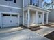 Close up of the charming house featuring a one-car garage and a welcoming porch with white columns at 187 Regis Ln # 10, Coats, NC 27521