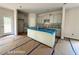 Modern kitchen island with sink and ample cabinet space, complemented by neutral walls and a view to the outdoors at 187 Regis Ln # 10, Coats, NC 27521