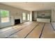 Open-concept living space with a fireplace, multiple windows, and a view into the adjacent kitchen area at 187 Regis Ln # 10, Coats, NC 27521