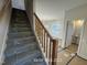 Carpeted stairway with natural wood banister leads to the upper level at 187 Regis Ln # 10, Coats, NC 27521
