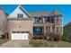 Inviting exterior showcasing a brick facade, two-car garage, manicured lawn, and covered front porch at 1950 Firenza Dr, Apex, NC 27502