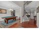 Spacious game room with a pool table, hardwood floors, and staircase at 1950 Firenza Dr, Apex, NC 27502