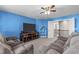 Bright blue living room featuring plush couches, entertainment center, and access to the second story at 1950 Firenza Dr, Apex, NC 27502