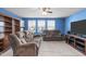 Spacious living room with plush couches, large window, ceiling fan, and entertainment center at 1950 Firenza Dr, Apex, NC 27502
