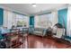 Bright living room featuring hardwood floors, large windows, and a comfortable hanging chair at 1950 Firenza Dr, Apex, NC 27502